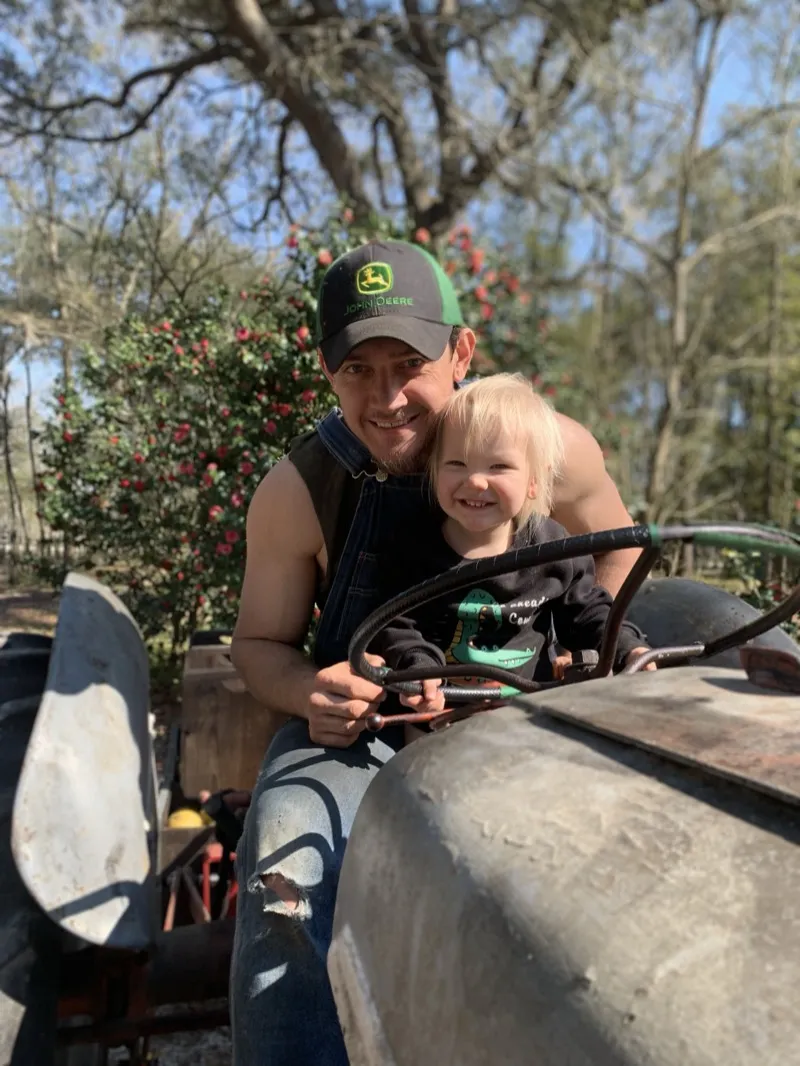 Marshall Rawson on the tractor with his child